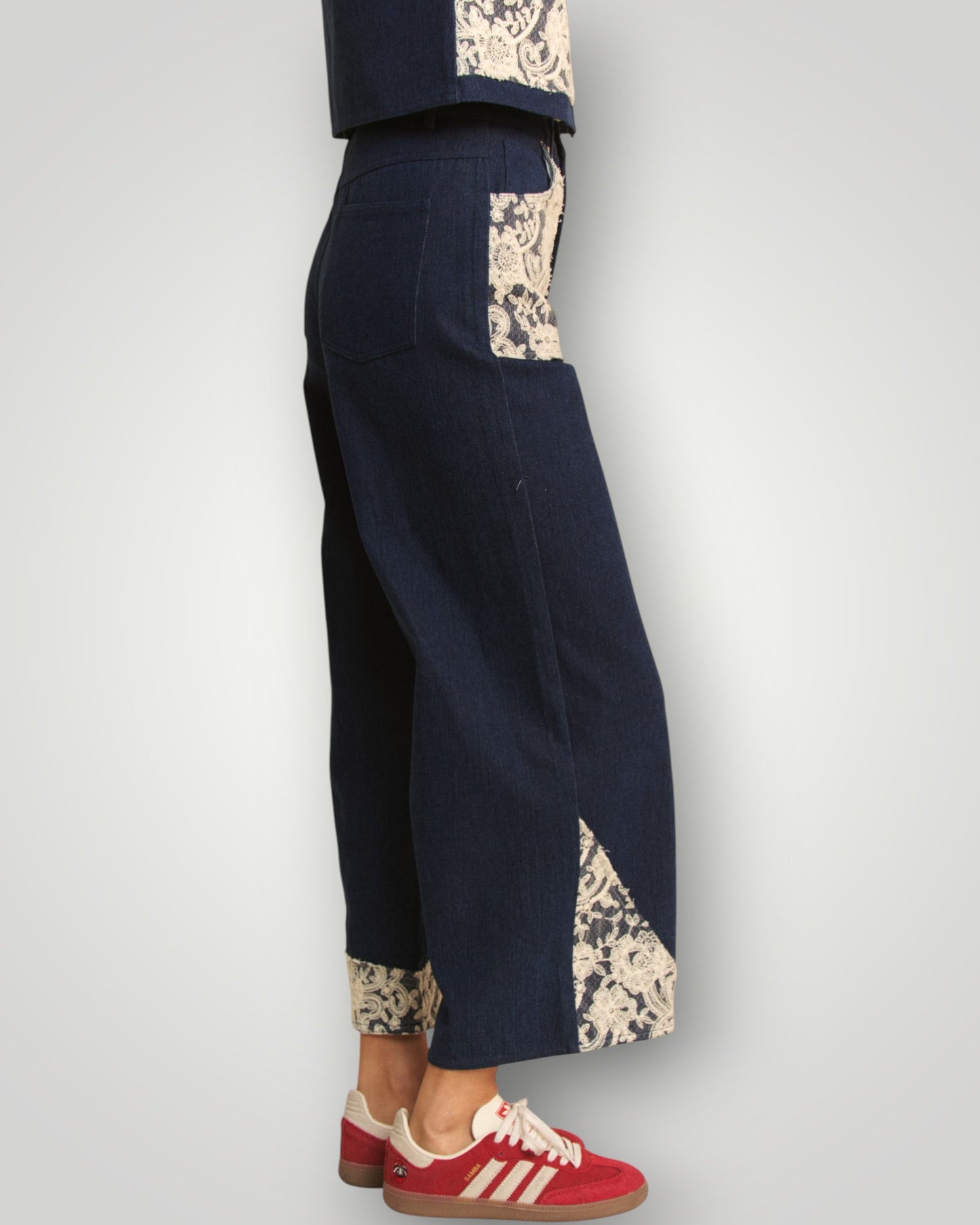 Navy pants with floral cuffs and hem on a white background