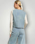 Person wearing a light blue vest and pants set on a plain background