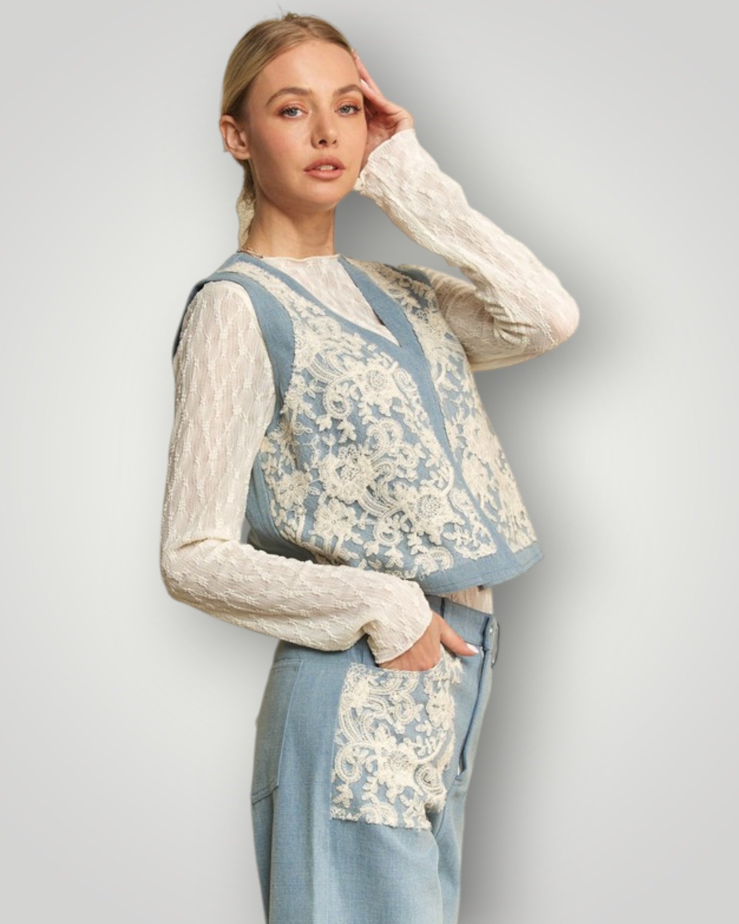 Woman wearing a patterned vest over a long-sleeve top with a plain background