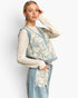 A woman models a light blue denim vest with cream lace overlay and matching light blue denim trousers against a plain light gray background.