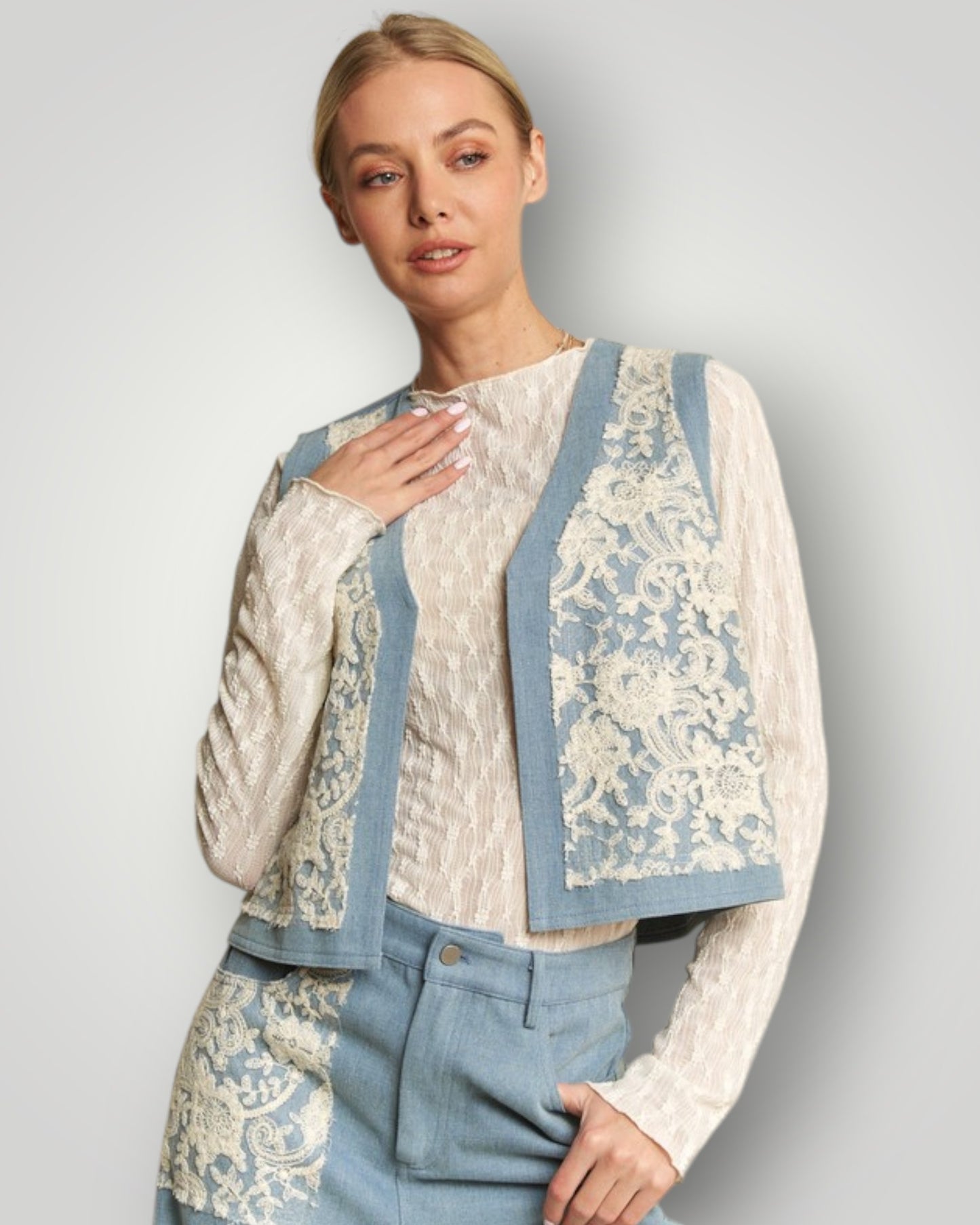 Woman wearing a floral jacket over a white blouse with blue accents on a light gray background