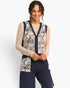 A woman modeling a cream and navy lace vest over a beige patterned long-sleeve top and navy wide-leg pants, photographed against a clean white studio background.