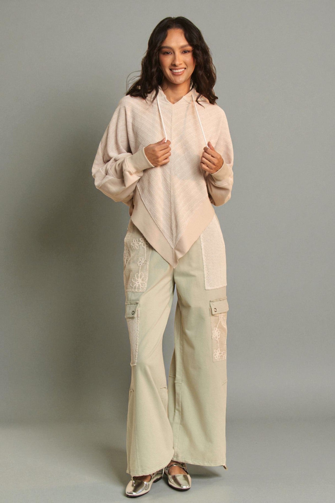 Woman wearing a beige outfit with a plain background