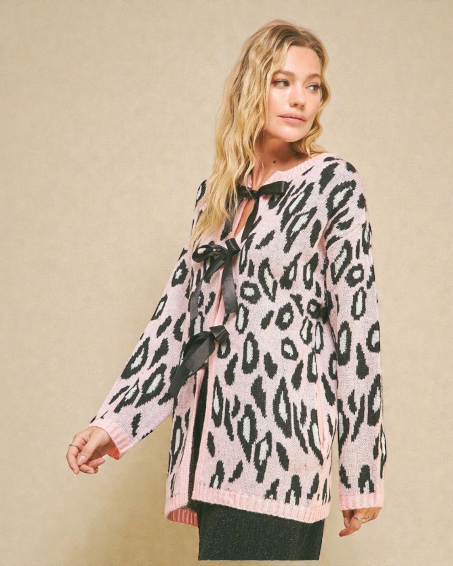 Woman wearing a leopard print blouse with a bow tie on a beige background