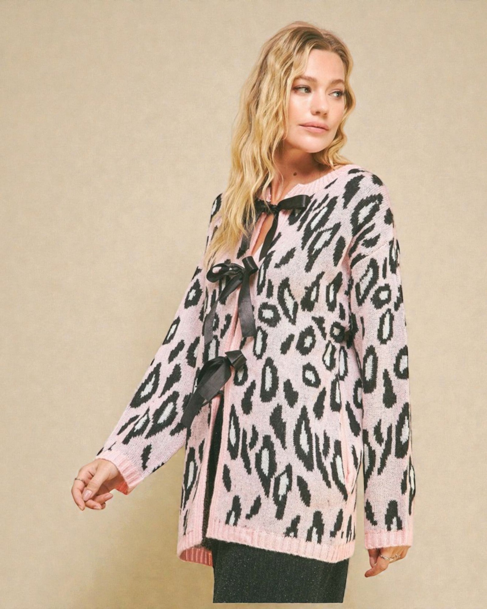 Woman wearing a leopard print blouse with a bow tie on a beige background