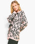 A woman modeling a pink and black leopard-print knit sweater against a plain white background.