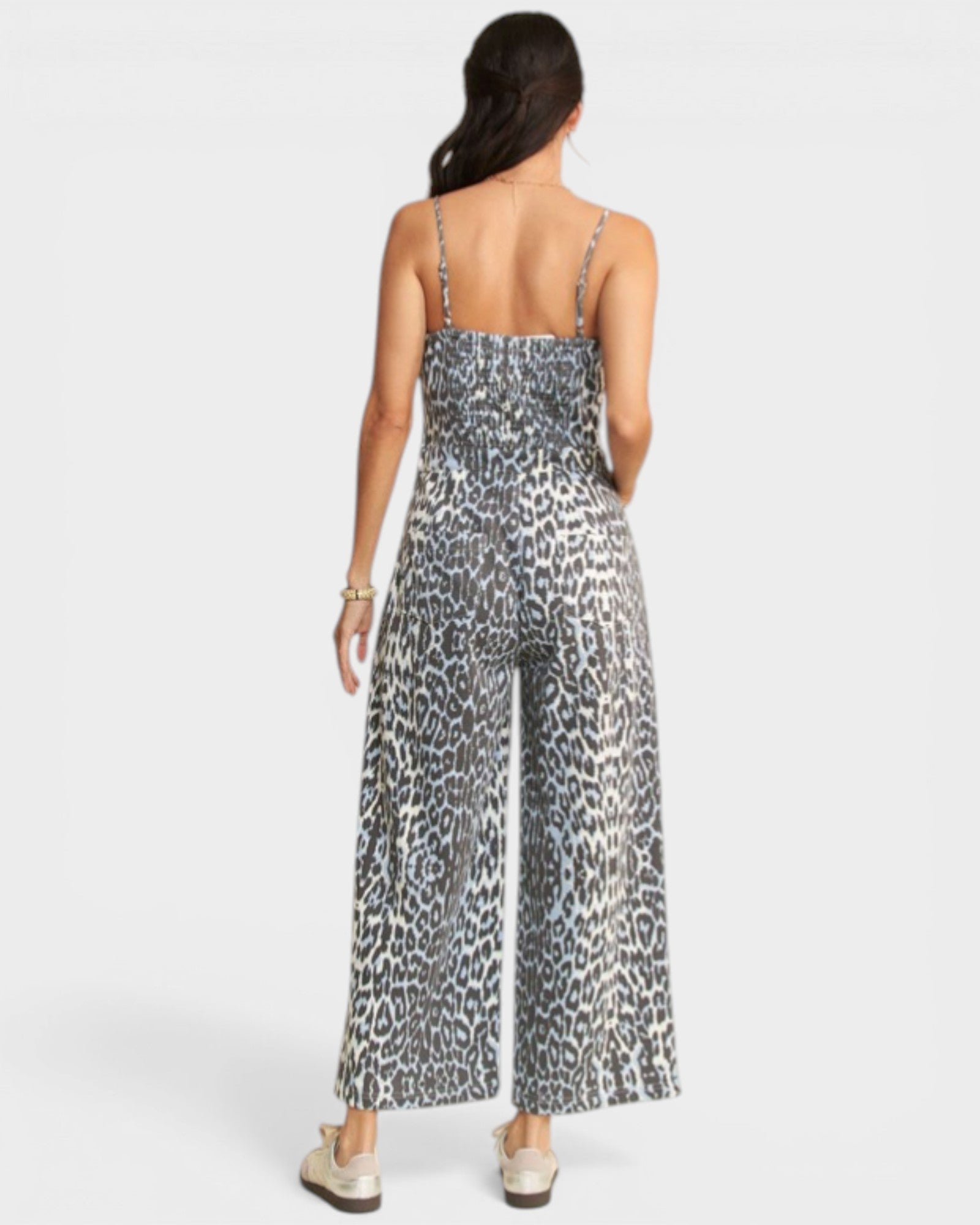 Person wearing a leopard print jumpsuit on a white background