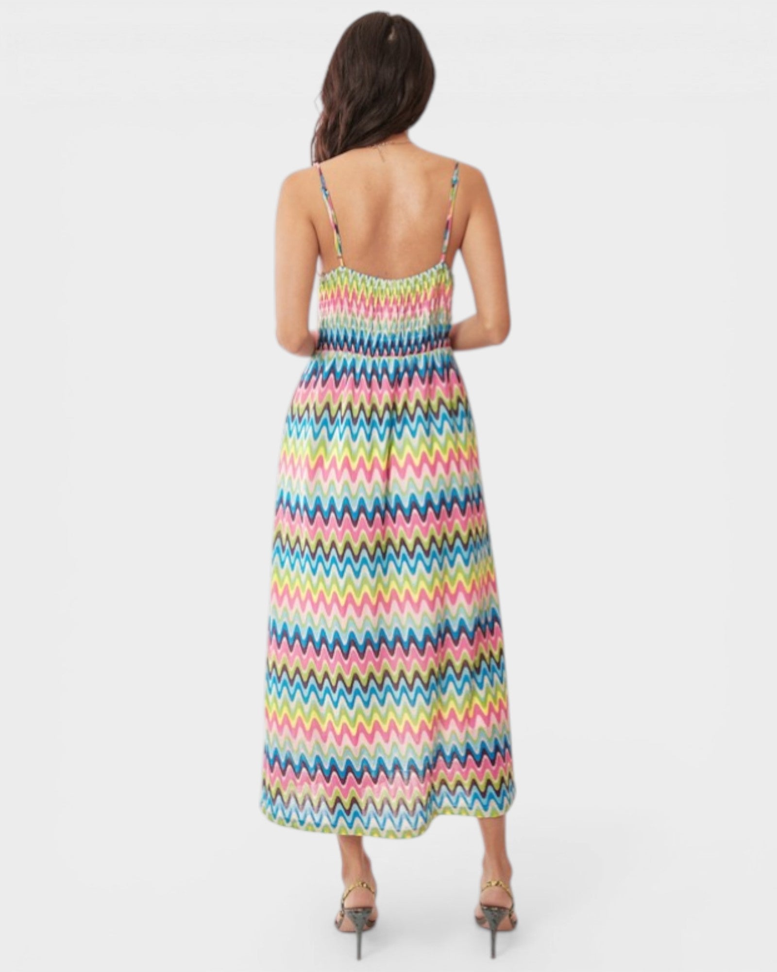 Woman wearing a colorful zigzag patterned dress on a white background