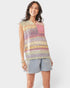 Woman wearing a colorful sleeveless crochet top and denim shorts on a white background