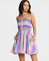 Woman wearing a colorful striped dress on a white background