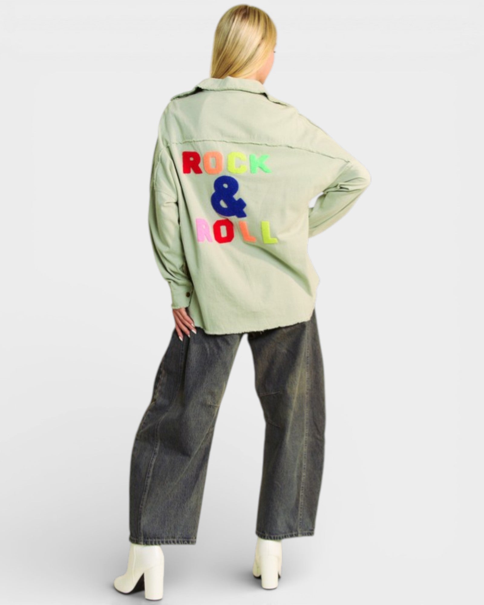 Person wearing a light green jacket with 'Rock & Roll' text on the back, standing against a white background.