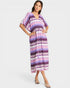 Woman wearing a colorful zigzag patterned dress on a white background