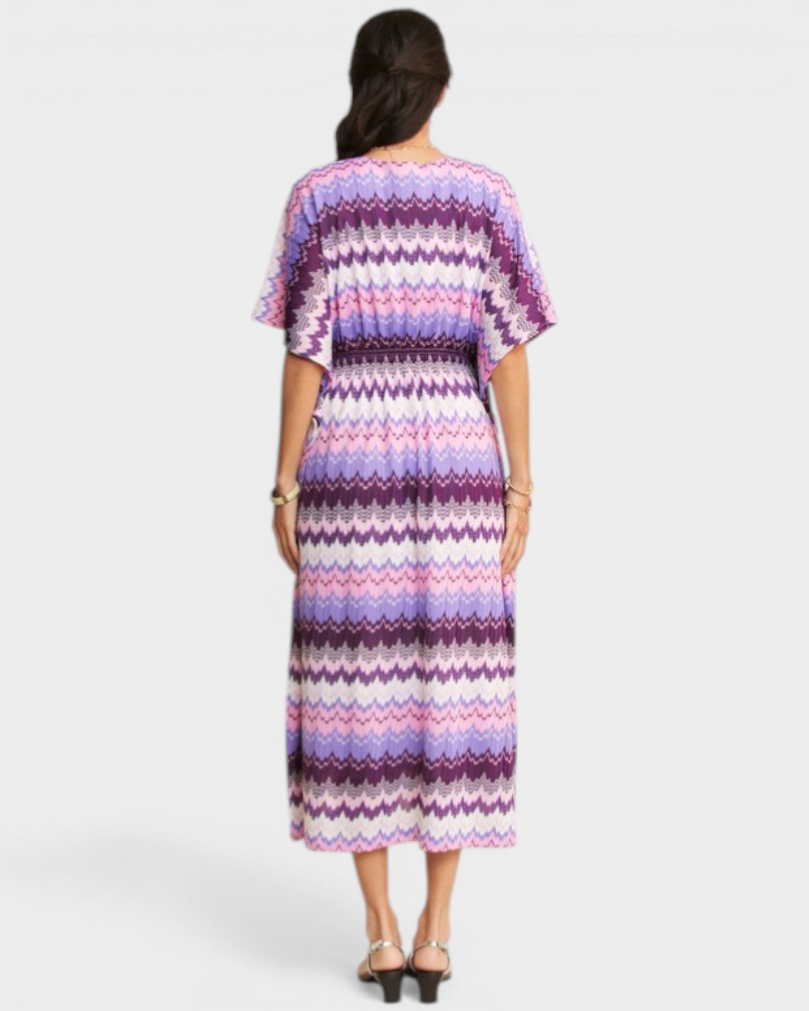 Woman wearing a patterned dress on a white background