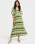 Woman wearing a green and white striped dress on a white background