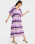 Woman wearing a colorful zigzag patterned dress on a white background