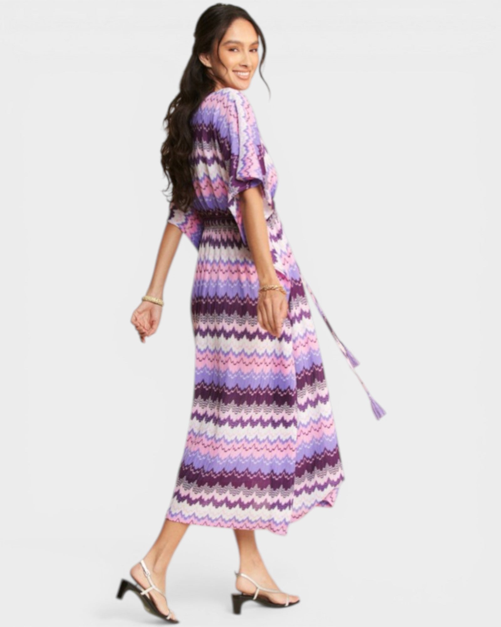 Woman wearing a colorful zigzag patterned dress on a white background