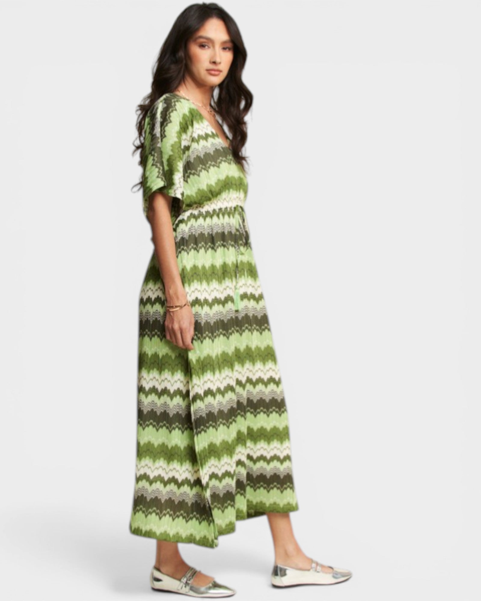Woman wearing a green and gray striped dress on a white background