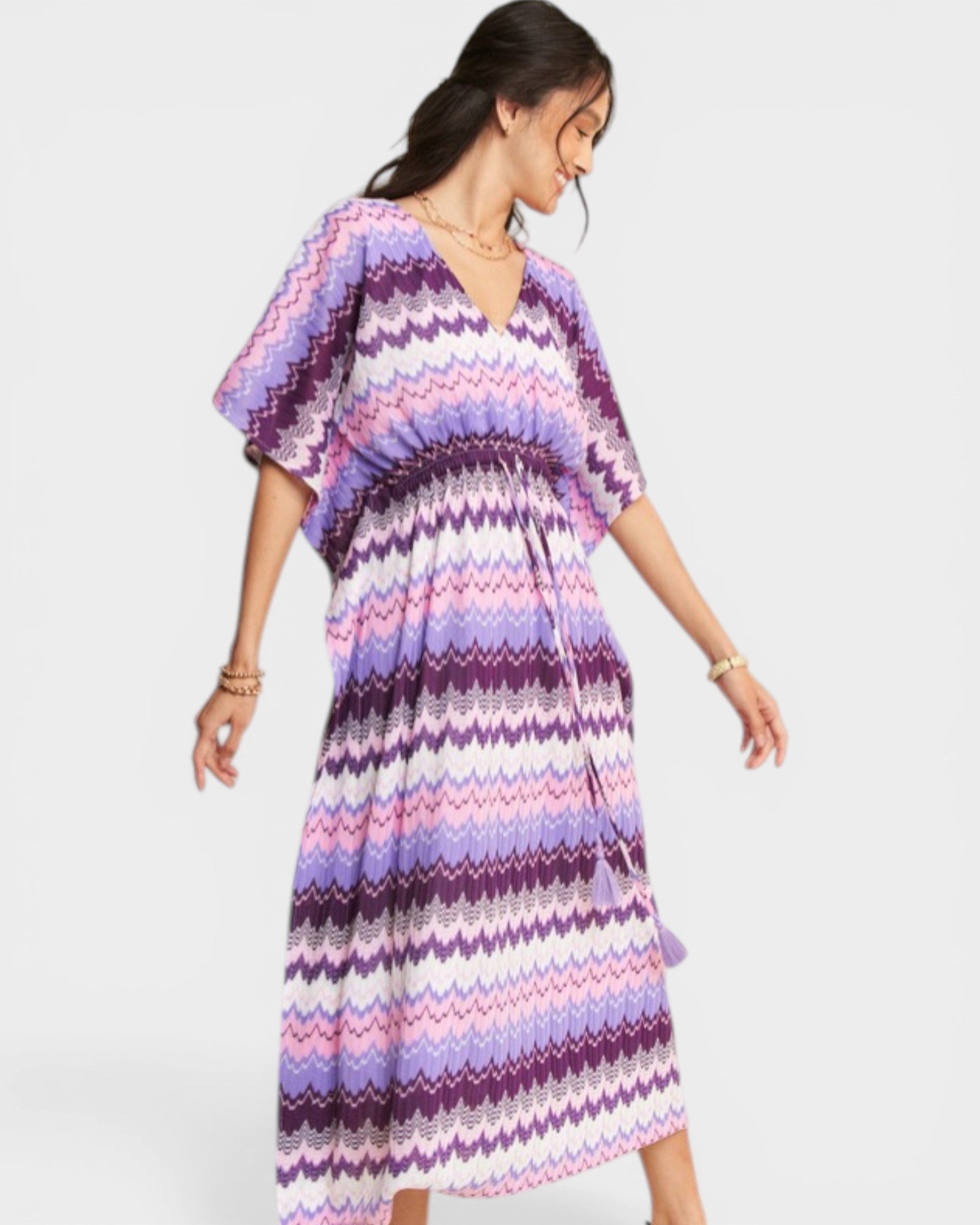 Woman wearing a colorful zigzag patterned dress on a white background