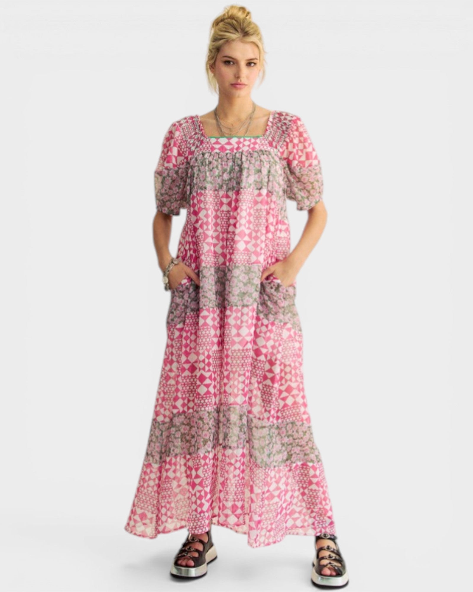 Woman wearing a pink and gray patterned dress on a white background