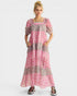 Woman wearing a pink and gray patterned dress on a white background