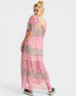 Woman wearing a pink and brown patterned dress on a white background