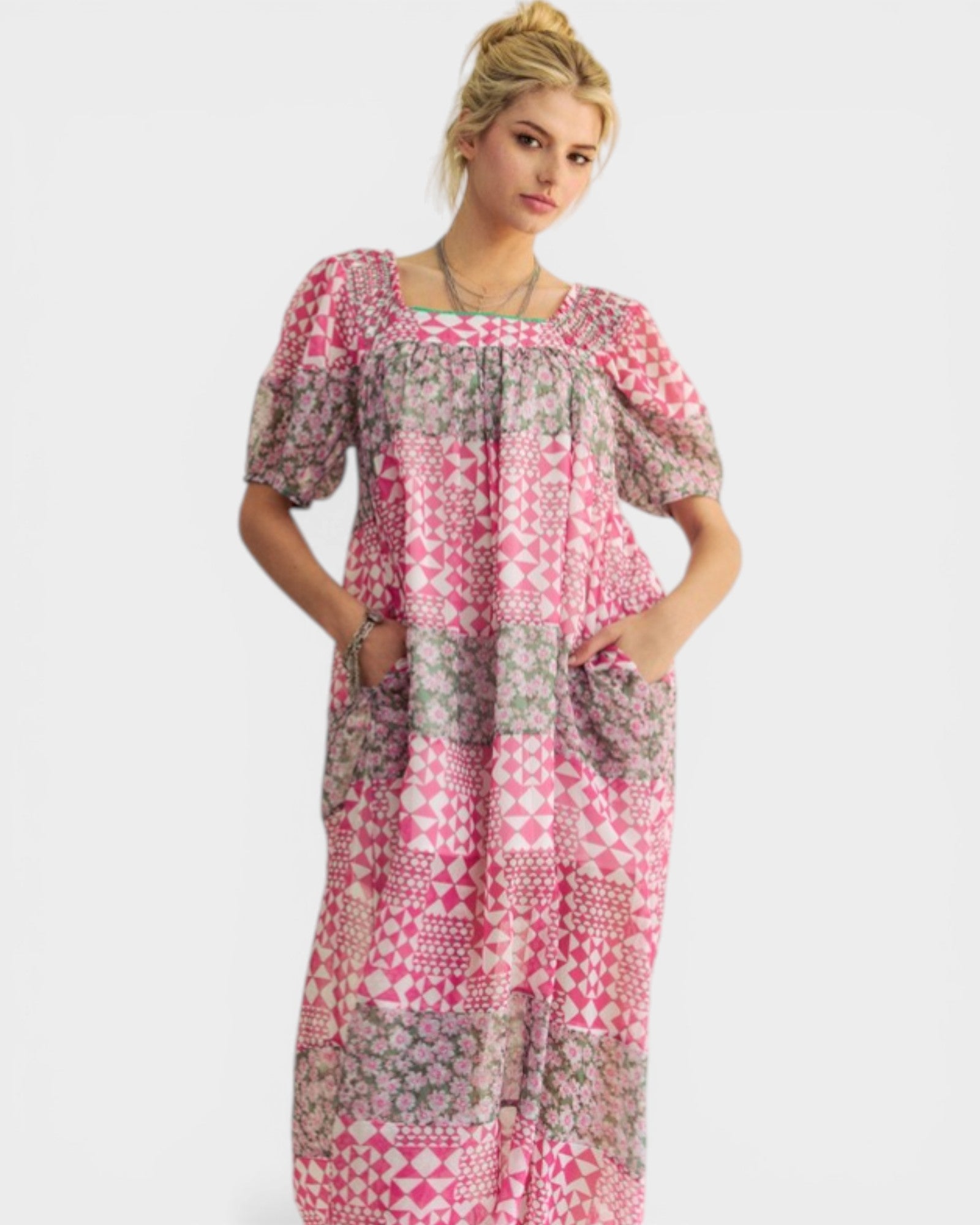 Woman wearing a pink and gray patterned dress on a white background