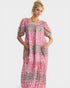 Woman wearing a pink and gray patterned dress on a white background