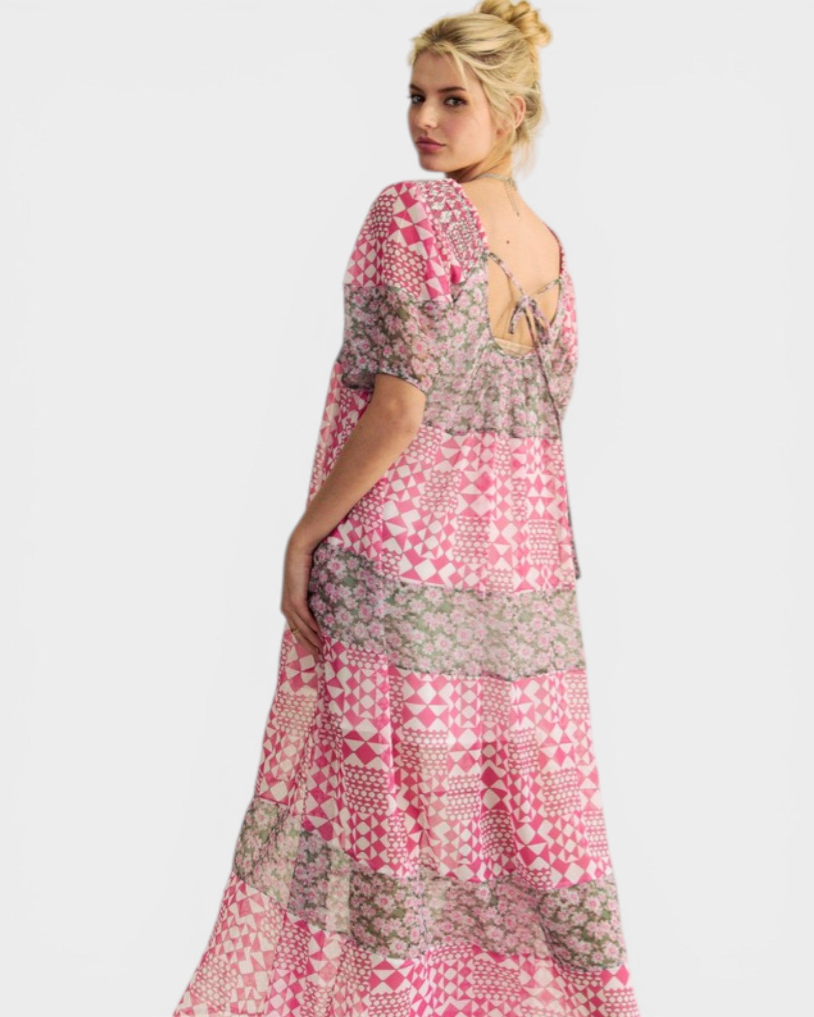 Woman wearing a pink and gray patterned dress on a white background