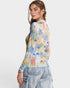 Woman wearing a colorful patterned shirt with a white background