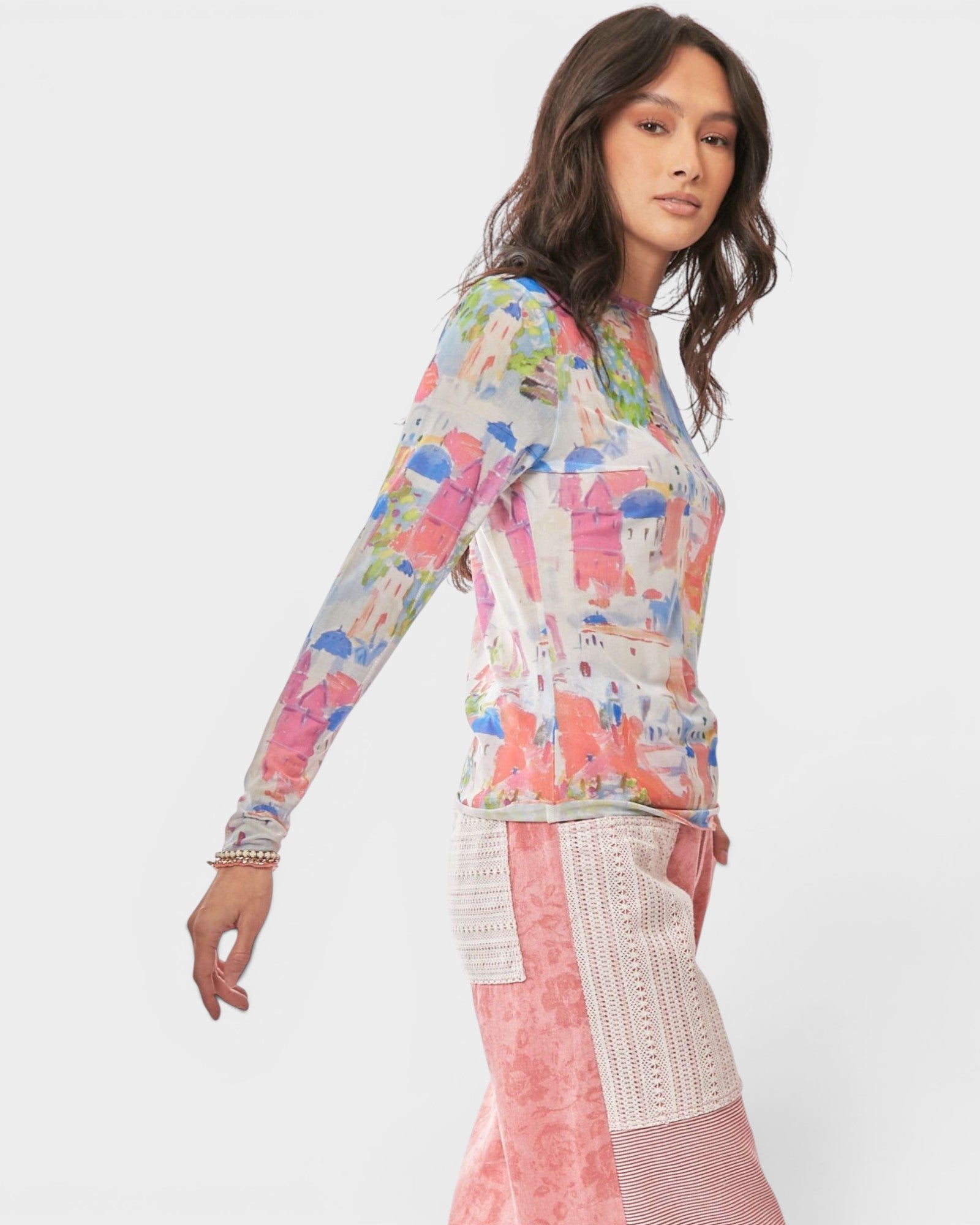 Woman wearing a colorful patterned top with a white background