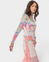 Woman wearing a colorful patterned top with a white background