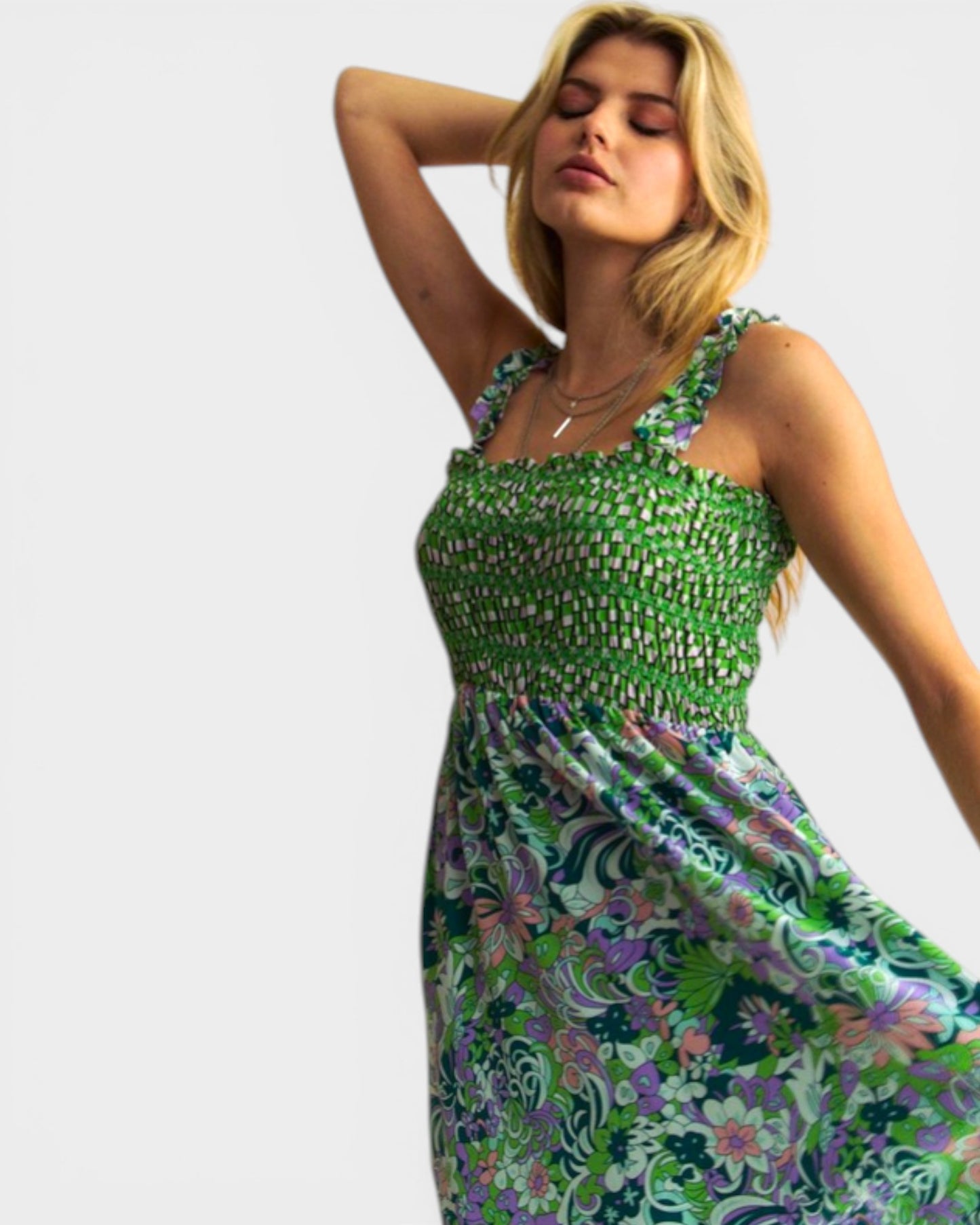 Woman wearing a green floral dress against a white background