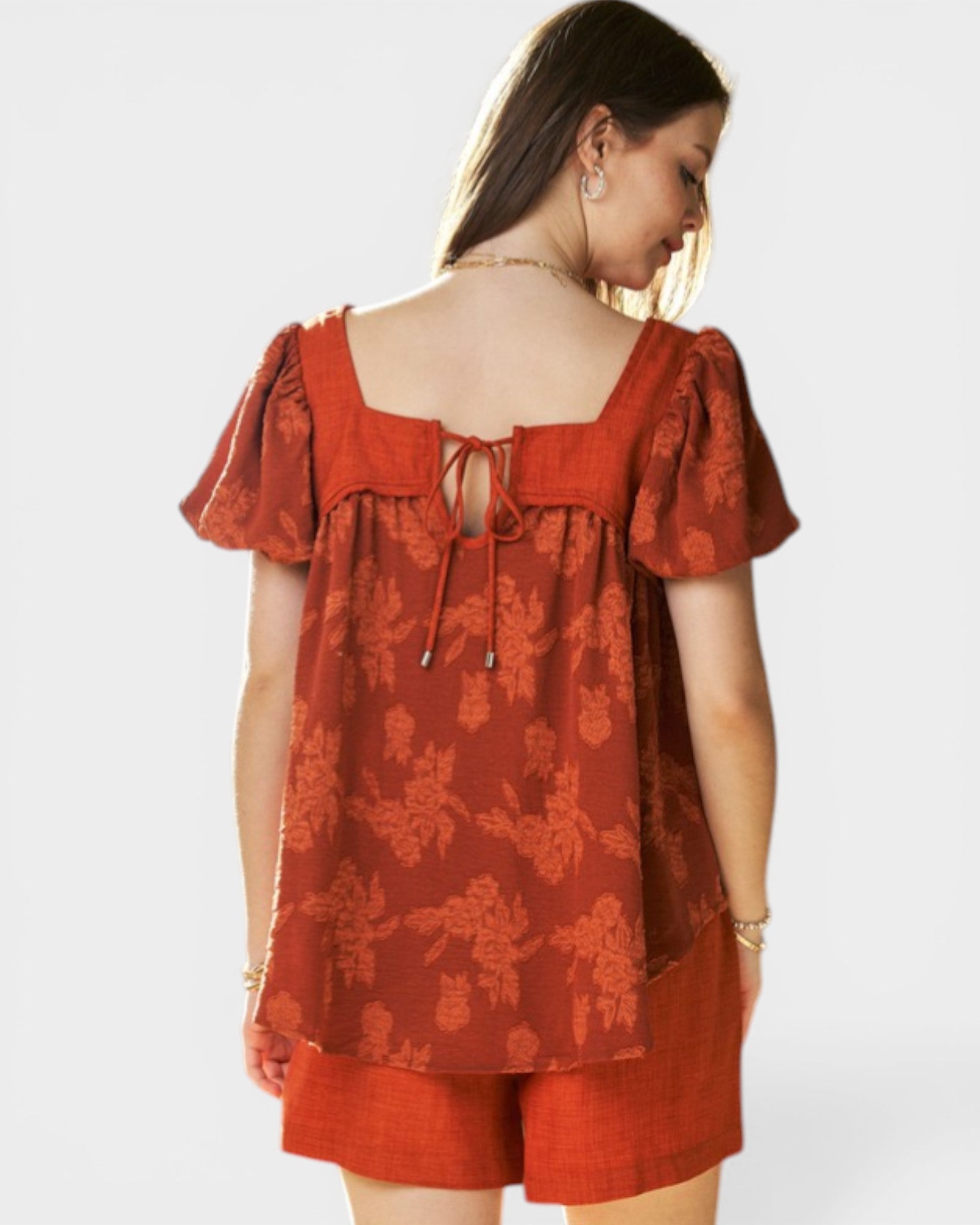 Woman wearing a red floral dress on a white background