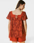 Woman wearing a red floral dress on a white background