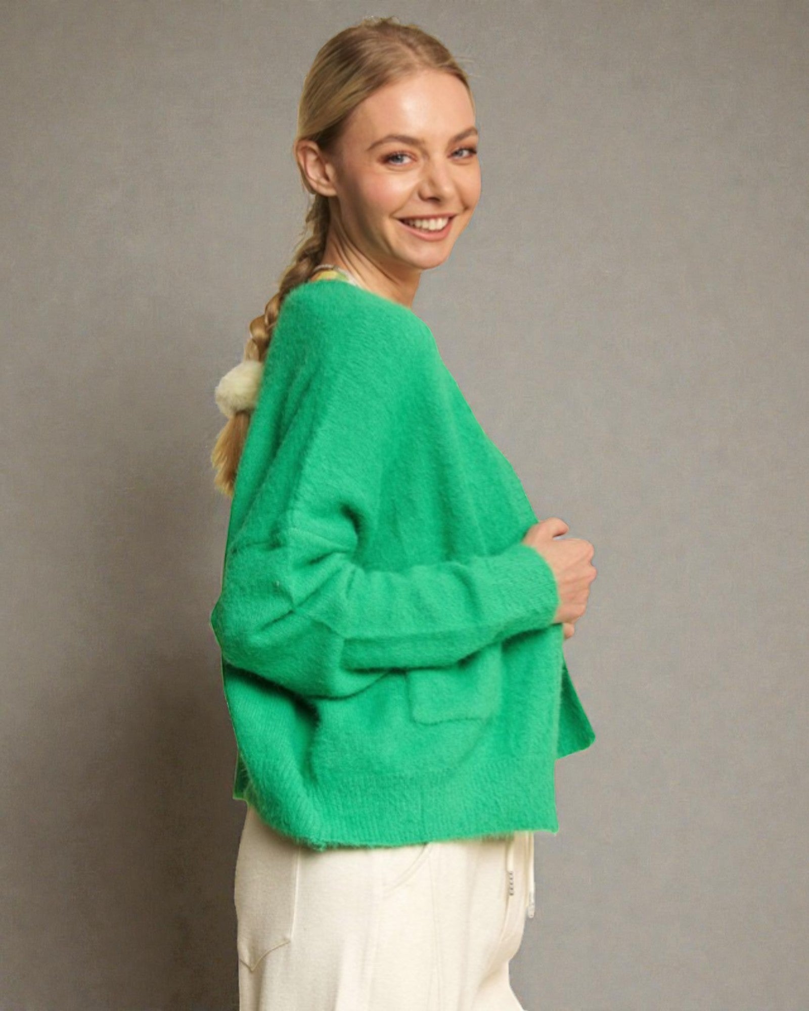 Woman wearing a green sweater against a gray background