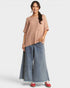 Woman wearing a beige top and blue jeans on a white background