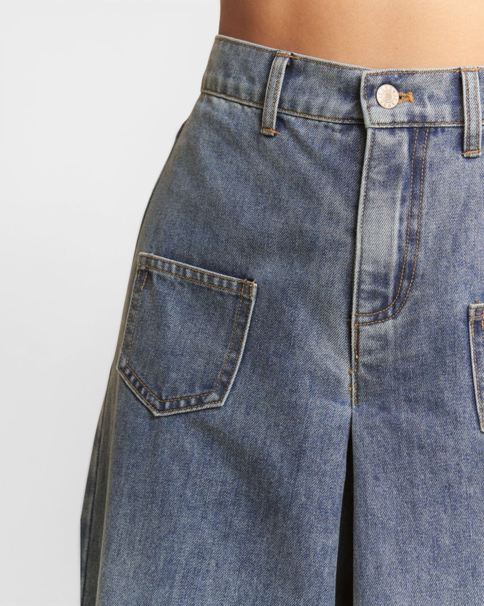 Close-up of blue jeans with a plain background