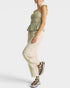 Woman wearing a plaid top and beige pants on a white background