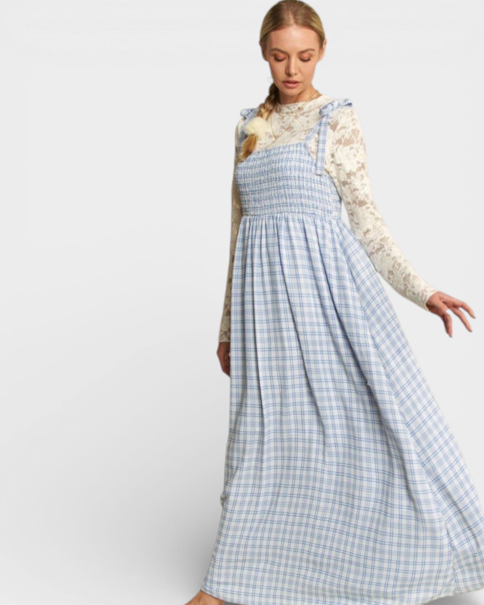 Woman wearing a blue checkered dress with a white background