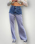 Person wearing a plaid shirt, denim jacket, and blue jeans on a plain background