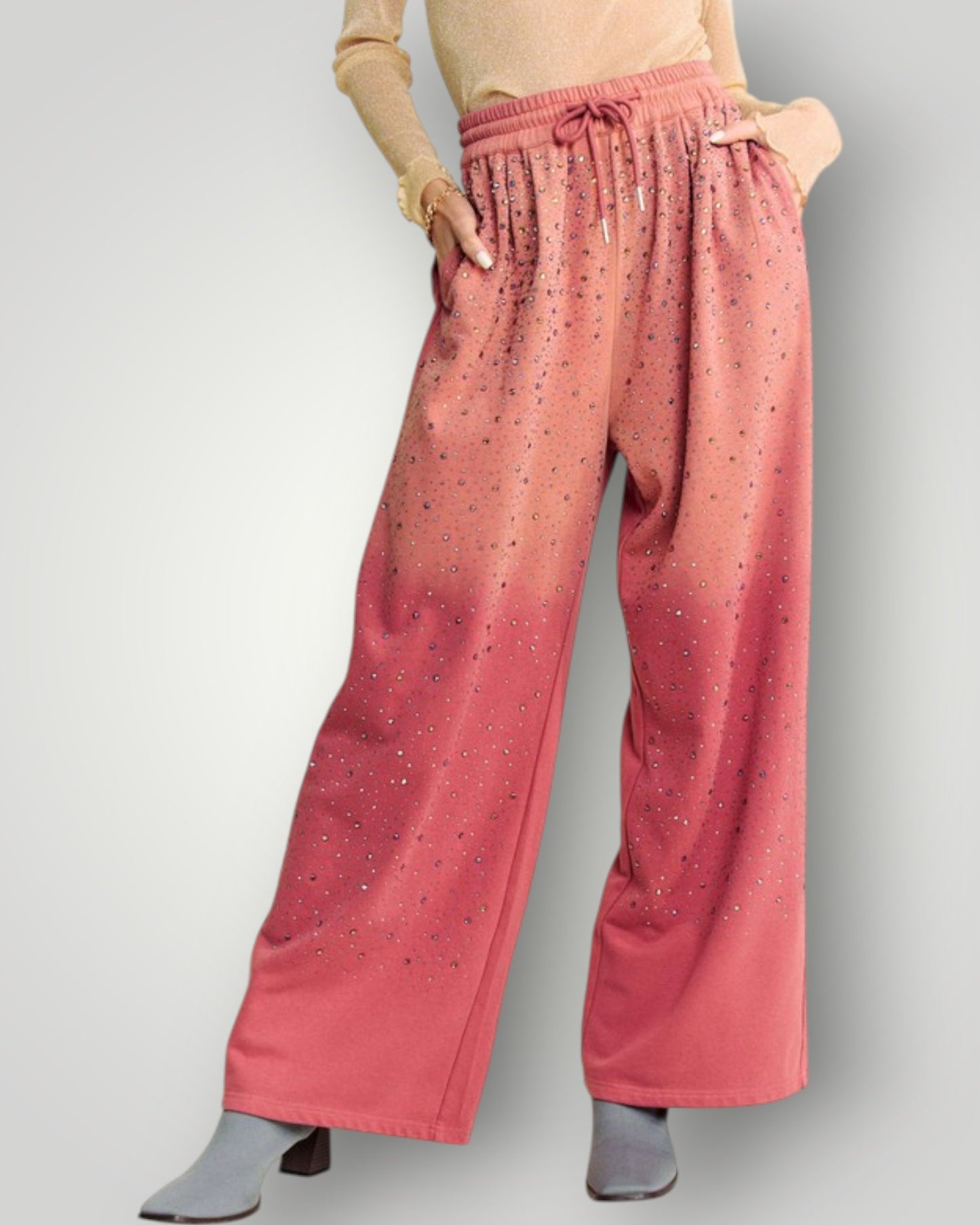 Person wearing pink wide-leg pants with a subtle pattern on a gray background