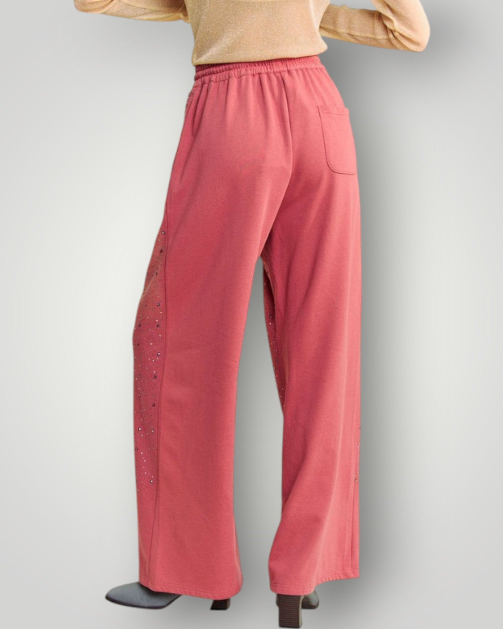 Pink pants with decorative side panels on a gray background