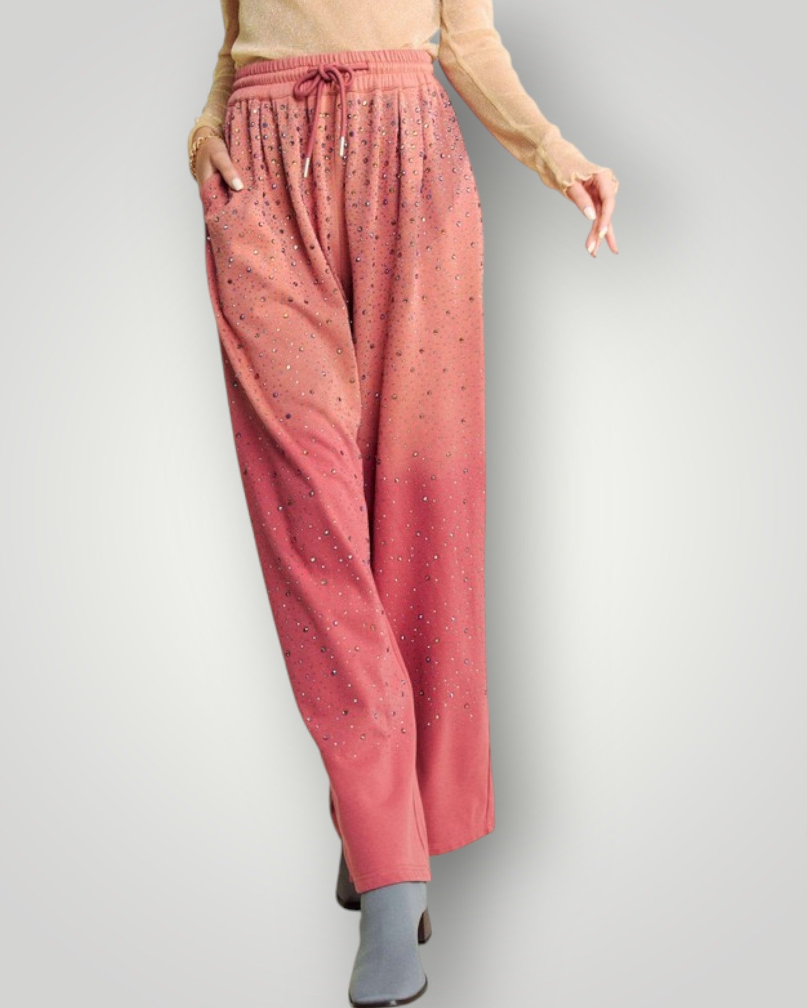 Person wearing pink pants with a subtle pattern on a plain background