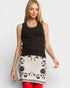 Woman wearing a black and white dress with floral patterns on a plain background