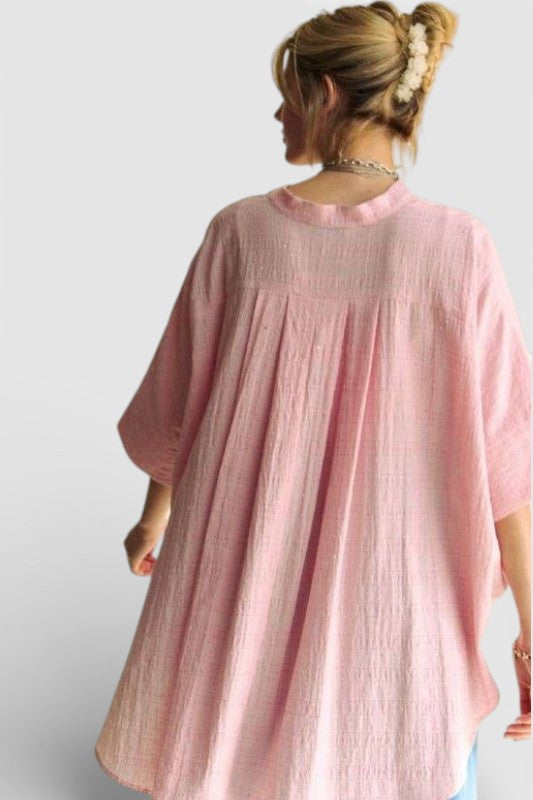 Person wearing a pink oversized garment against a white background