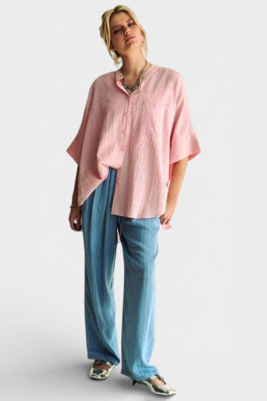 Person wearing a pink shirt and blue pants on a white background