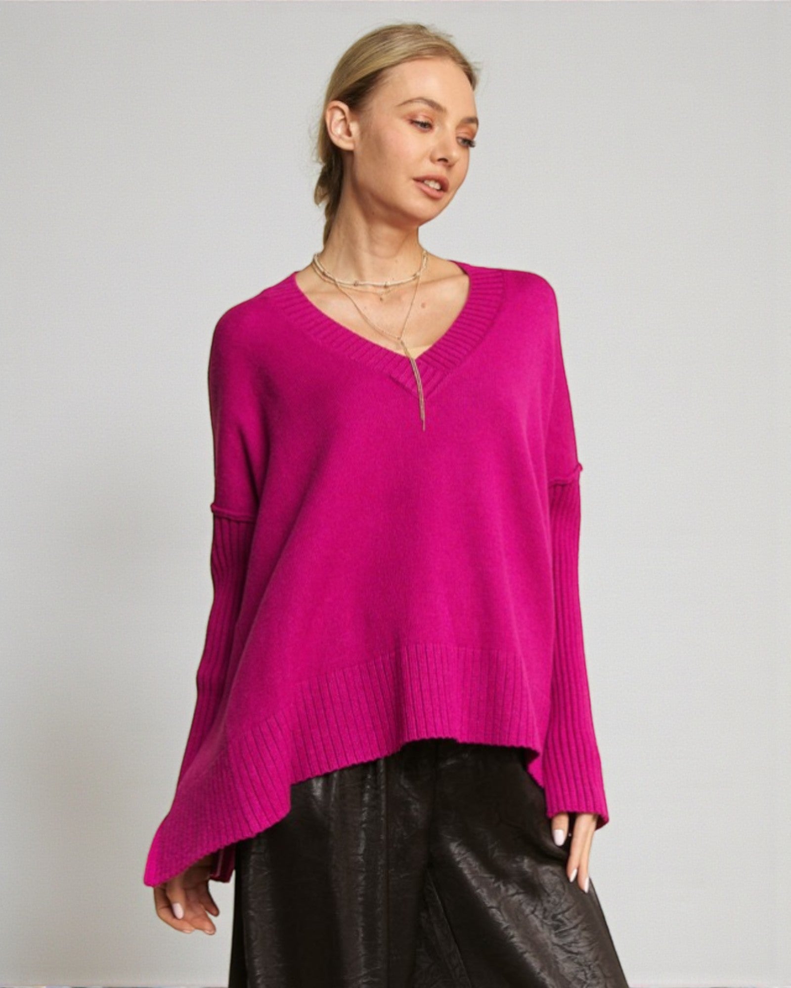 Woman wearing a bright pink sweater against a plain background
