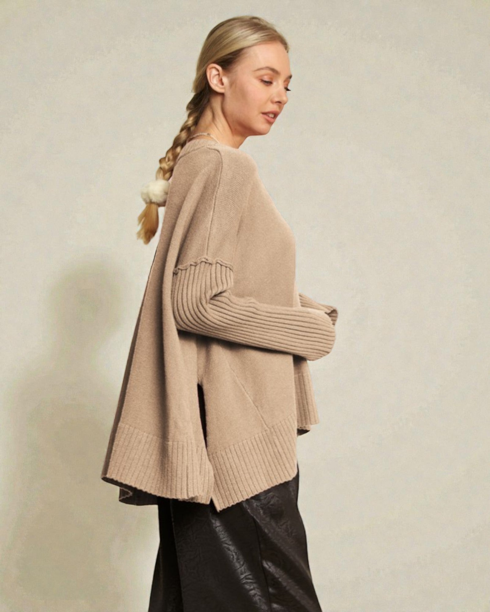 Woman wearing a beige cardigan against a plain background