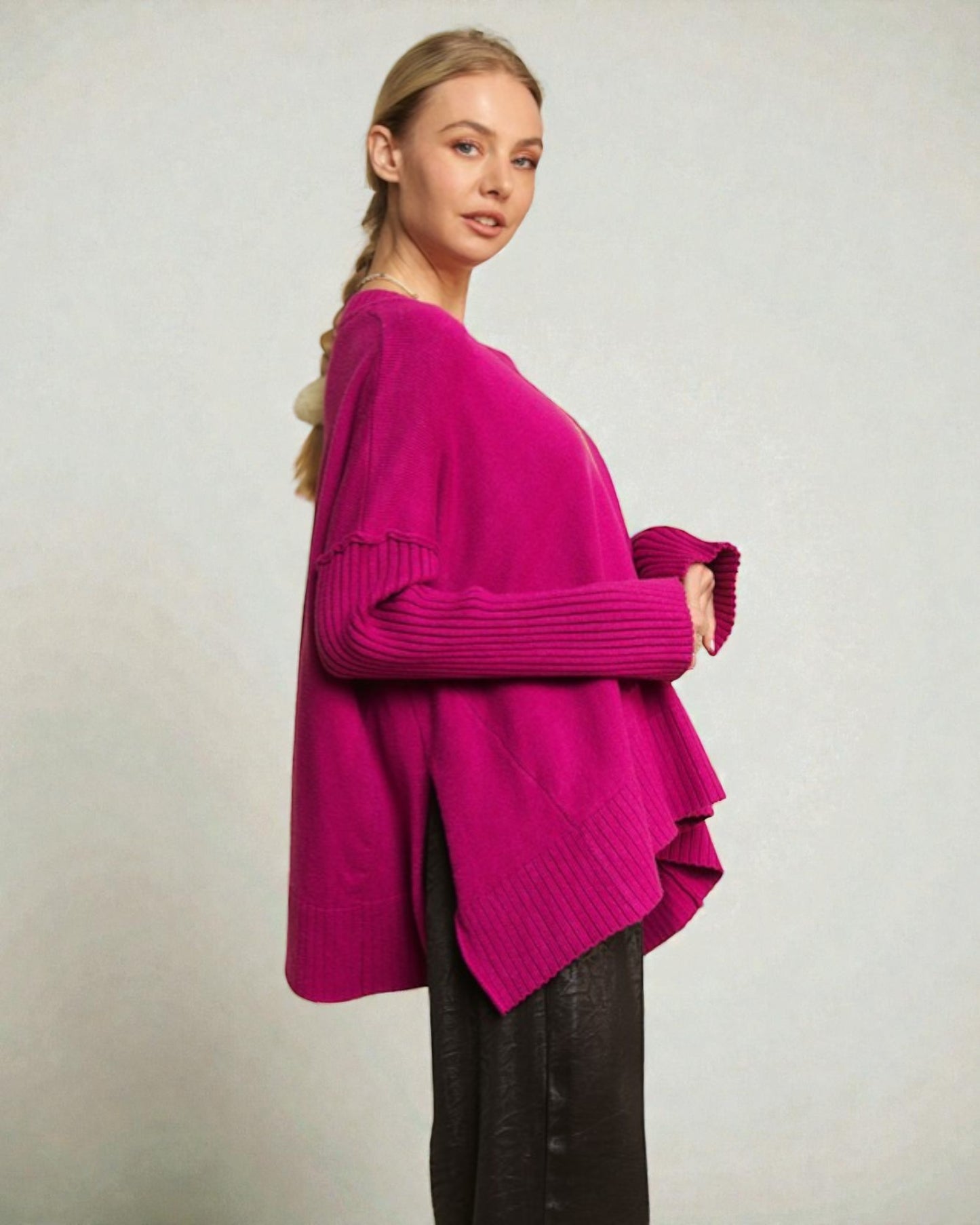 Woman wearing a bright pink sweater against a plain background
