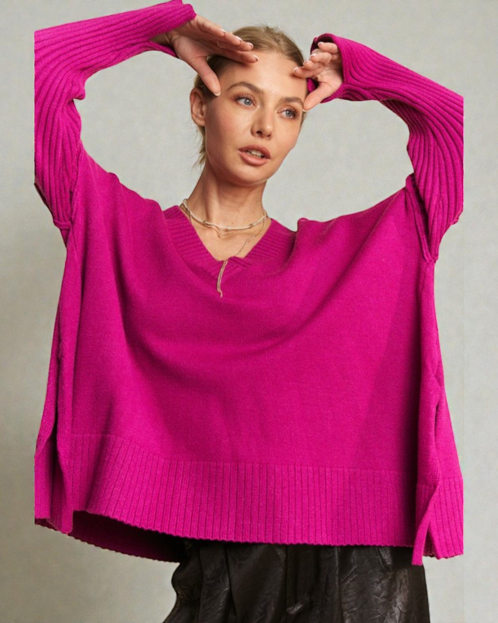 Woman wearing a bright pink sweater against a neutral background